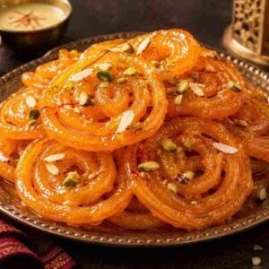 Menu Authentic Indian jalebi dessert with crisp golden spirals, sugar syrup and pistachios at RAASARA